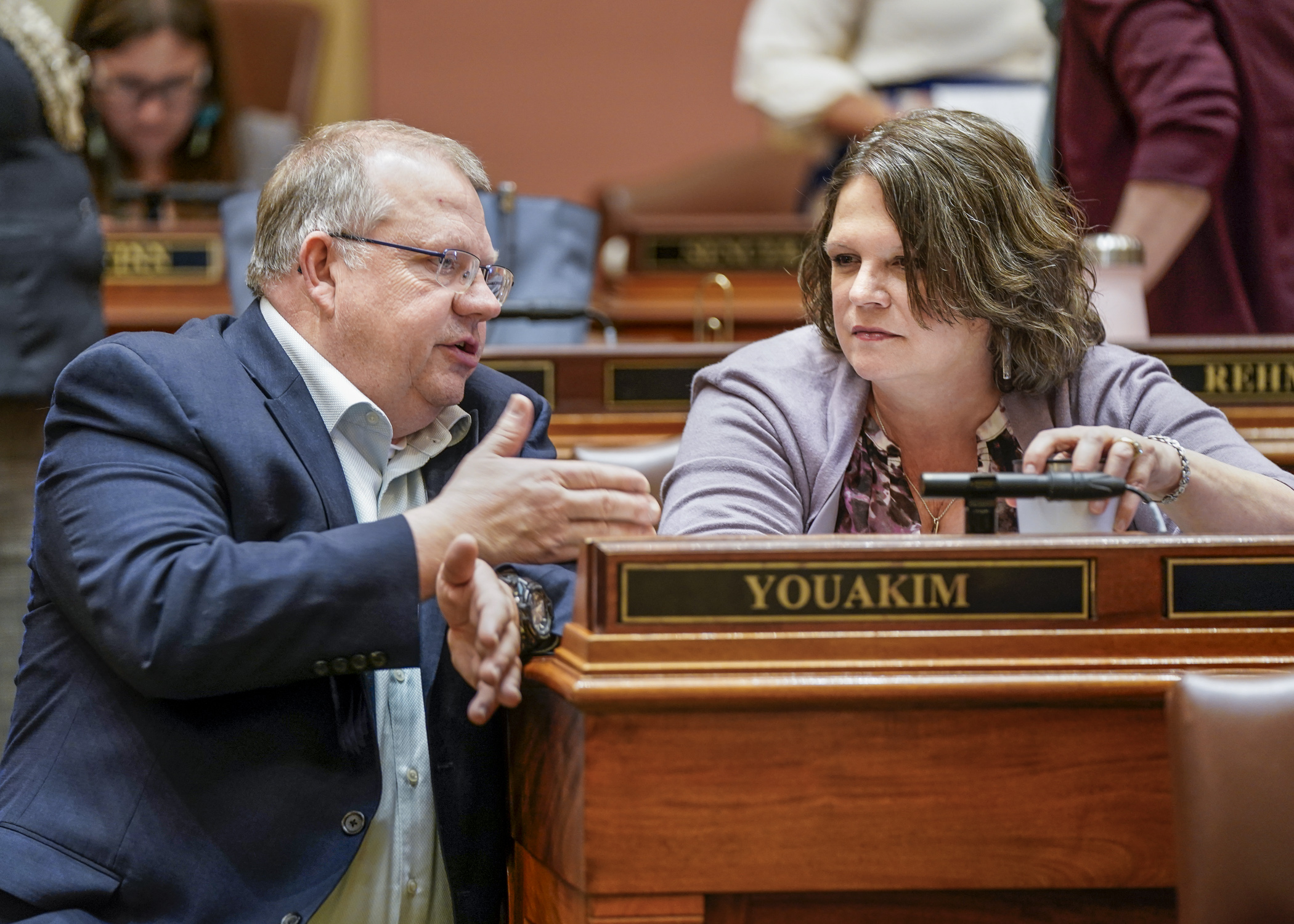 Rep. Ron Kresha and Rep. Cheryl Youakim converse during a floor session April 12. (Photo by Catherine Davis)